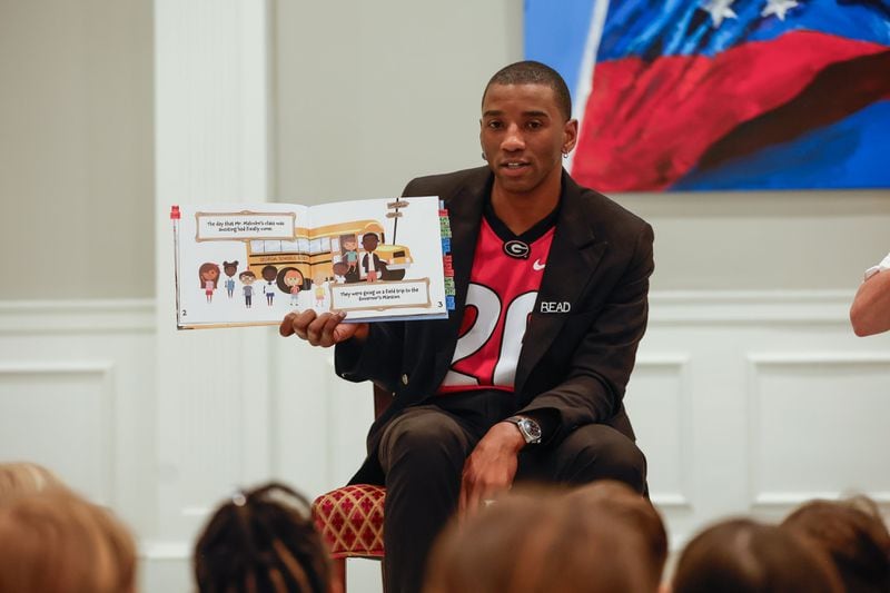 Former UGA football star Malcolm Mitchell is pictured reading his new book to pre-K students from Heards Ferry Elementary School last month.