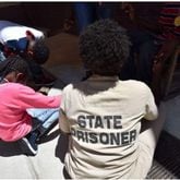 An inmate at Pulaski State Prison in Hawkinsville prays with her children in August 2016. An Emory graduate writes about escorting children to the prison to visit with their mothers.  (Hyosub Shin / AJC)