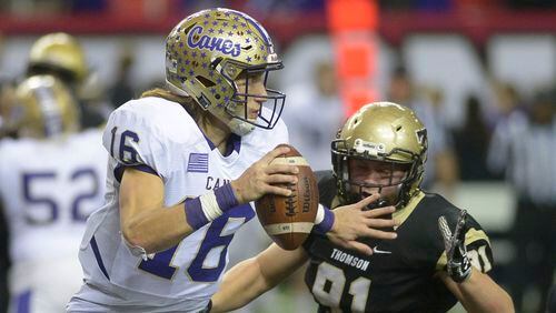 Cartersville quarterback Trevor Lawrence (16) eludes Thomson defensive Will Roberts in a 2016 game. AJC file photo