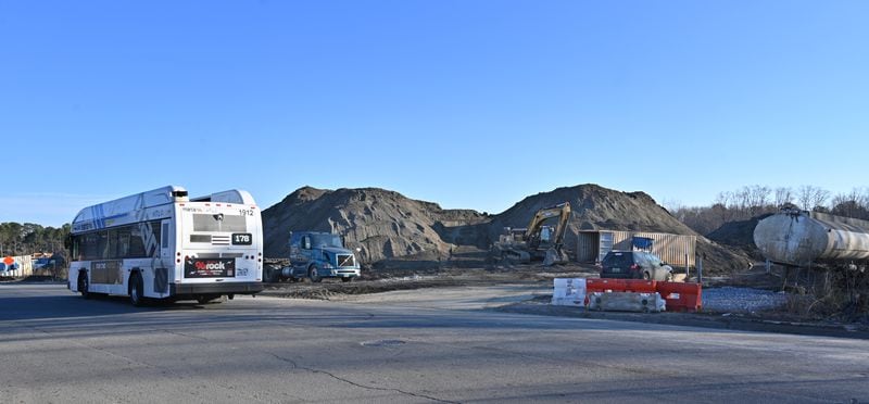 A MARTA bus travels past waste piles on the property of the TAV Holdings Inc. site in south Atlanta. An ongoing EPA investigation is examining how far pollution has spread into the surrounding neighborhood, which is mostly home to Black and lower income residents. 