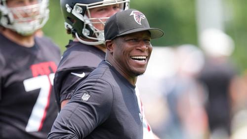 Atlanta Falcons head coach Raheem Morris laughs with his players during an NFL football practice Monday, June 3, 2024, in Flowery Branch, Ga. (AP Photo/John Bazemore)