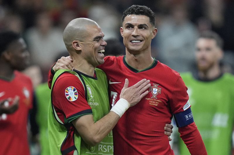 Portugal's Pepe, left, and Cristiano Ronaldo celebrate their win in penalties shootouts after a round of sixteen match between Portugal and Slovenia at the Euro 2024 soccer tournament in Frankfurt, Germany, Monday, July 1, 2024. (AP Photo/Matthias Schrader)