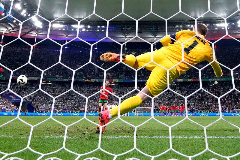 Portugal's Bernardo Silva scores the decisive penalty goal during a round of sixteen match between Portugal and Slovenia at the Euro 2024 soccer tournament in Frankfurt, Germany, Monday, July 1, 2024. (AP Photo/Matthias Schrader)