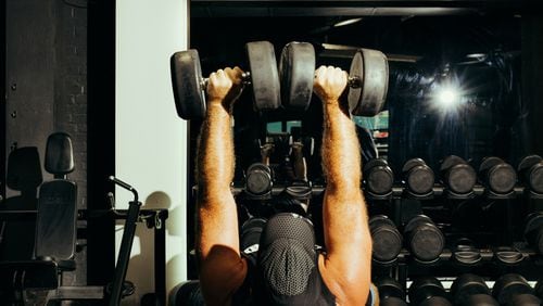 A man lifts weights at the gym in New York, July 21, 2021. Thousands of people each year partake in the 75-day program meant to build “mental toughness,” according to its creator, but health experts caution the program may be too rigid and intense. (George Etheredge/The New York Times)