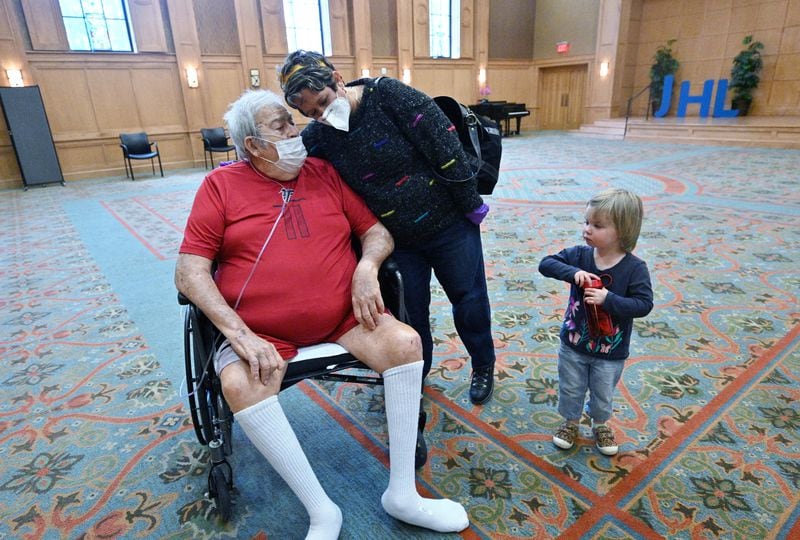 Ann Schepps, daughter-in-law, hugs Larry Schepps (left) as she and her granddaughter Penton, 2, leave after a 20-minute face-to-face visitation at The William Breman Jewish Home in Atlanta on Thursday. (Hyosub Shin / Hyosub.Shin@ajc.com)