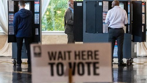 Reed Pitre, from left, Joe Trahan and Kenji Robinson cast their votes in the Georgia primary on Tuesday at the polling place at the Park Tavern located at 500 10th St. NE in Atlanta. (John Spink/AJC)