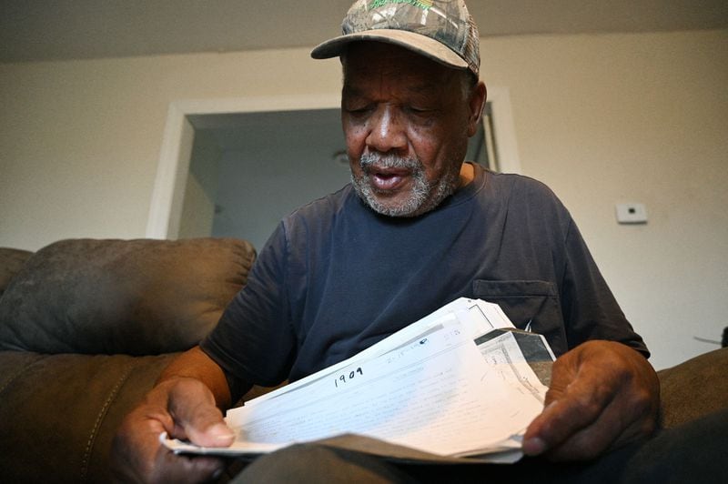 William Pierce, 82, holds the deed for the property his father purchased in 1919 in Tennille. The family no longer owns that land, but Pierce lives on 17 acres adjacent to it. (Hyosub Shin / AJC)