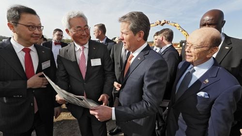 March 19, 2019 - Atlanta - Chey Jae won (from left), SK Executive Vice Chairman, Kim Jun, SK CEO, Gov. Brian Kemp, and U.S. Secretary of Commerce Wilbur Ross look over a full page ad in The Atlanta Journal Constitution promoting the new factory. The South Korean automotive battery maker broke ground in March on a new nearly $1.7 billion battery plant in Jackson County, one of the largest single economic development projects in the state’s history and one that will bring a significant foreign investment — and 2,000 jobs. Bob Andres / bandres@ajc.com