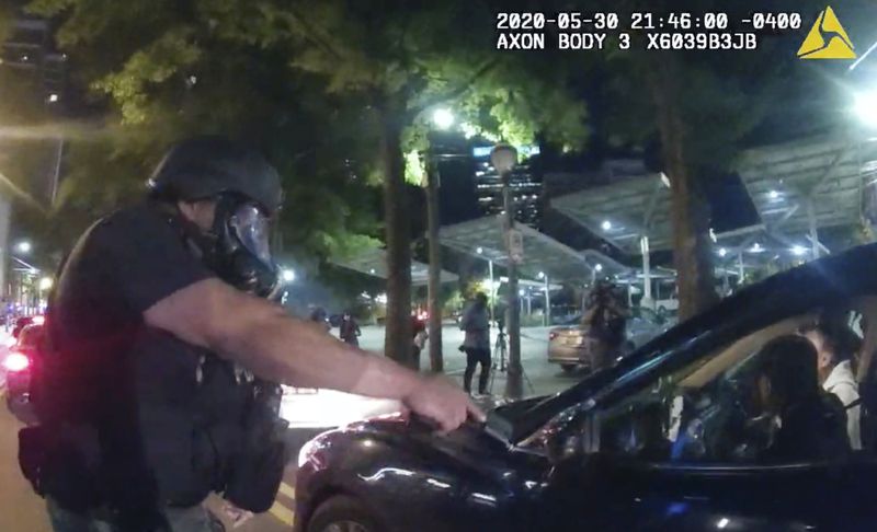 FILE - This image taken from Atlanta Police Department body camera footage shows an officer pointing his handgun at Messiah Young while the college student is seated in his vehicle, May 30, 2020, in Atlanta. On Monday, July 1, 2024, the Atlanta City Council approved the payment of a settlement of $2 million to Young and Taniyah Pilgrim, two college students who were shocked with Tasers and pulled from a car while they were stuck in downtown traffic caused by protests over George Floyd's killing. (Atlanta Police Department via AP, File)