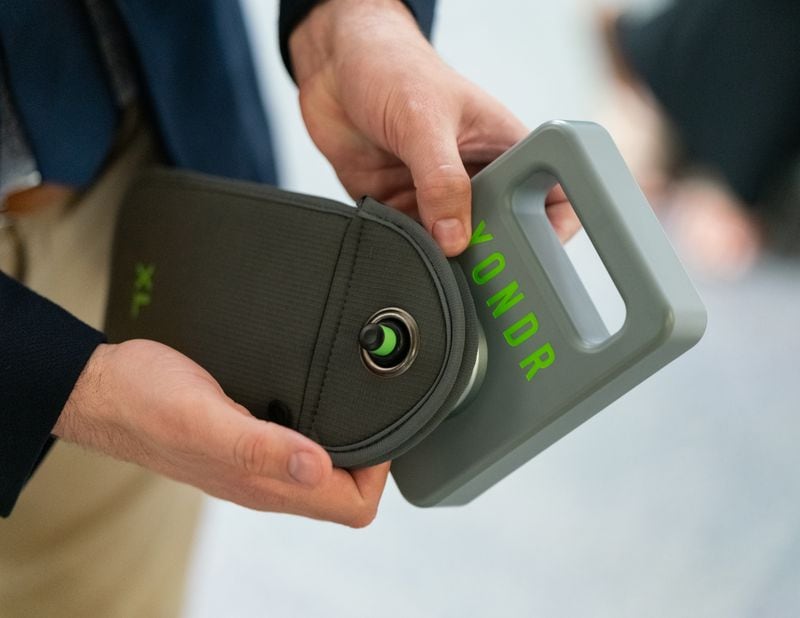 A Marietta City Schools employee demonstrates the use of the phone locking bags to be used in its middle schools starting the 2024-25 school year. (Ben Hendren for The Atlanta Journal-Constitution)