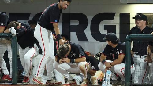 Georgia outfielder John Marant, standing, consoles Georgia third baseman Charlie Condon, center, after their 8-5 loss to N.C. State in Game 3 of the NCAA Super Regional at Foley Field, Monday, June 10, 2024, in Athens, Ga. (Jason Getz / AJC)
