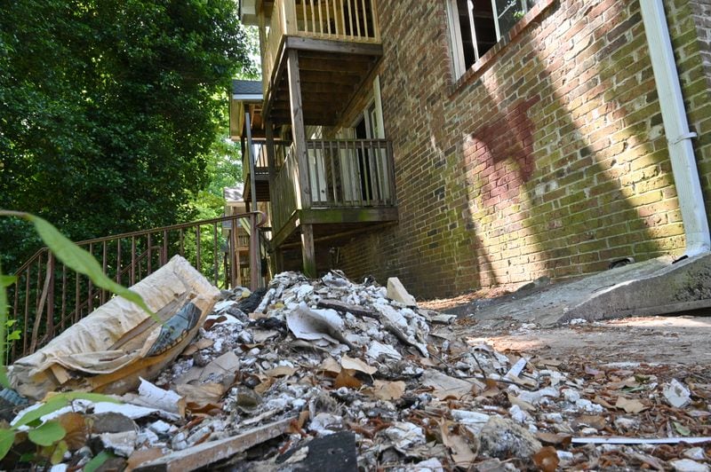 A pile of debris sits behind Pavilion Place's building 15 on May 10. Residents complained that trash and junk often sat on the grounds of the apartment complex. (Hyosub Shin / hyosub.shin@ajc.com)