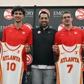Hawks draft picks Zaccharie Risacher (left) and Nikola Djurišić (right) hold up jerseys as they pose with general manager Landry Fields during a press conference at Emory Sports Medicine Complex, Friday, June 28, 2024, in Brookhaven. (Hyosub Shin / Hyosub.Shin@ajc.com)