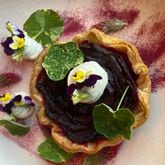 The beet root tart at Auburn Angel brings a stunning rose petal arrangement of cooked, sliced beets tucked inside a pastry shell with garnishes of goat cheese mousse, nasturtium leaves and flowers, crimson clover and beet root dust. (Ligaya Figueras/lfigueras@ajc.com)