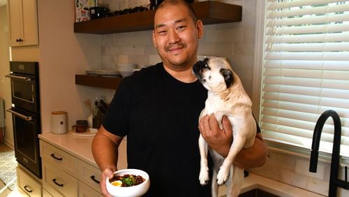 James Beard Award-nominated Brian So of Spring restaurant hangs out with one of his favorite pugs, Freddie. When So cooks for himself, his food leans toward Korean, the cuisine he grew up eating at home in Kennesaw. (CHRIS HUNT FOR THE ATLANTA JOURNAL-CONSTITUTION)