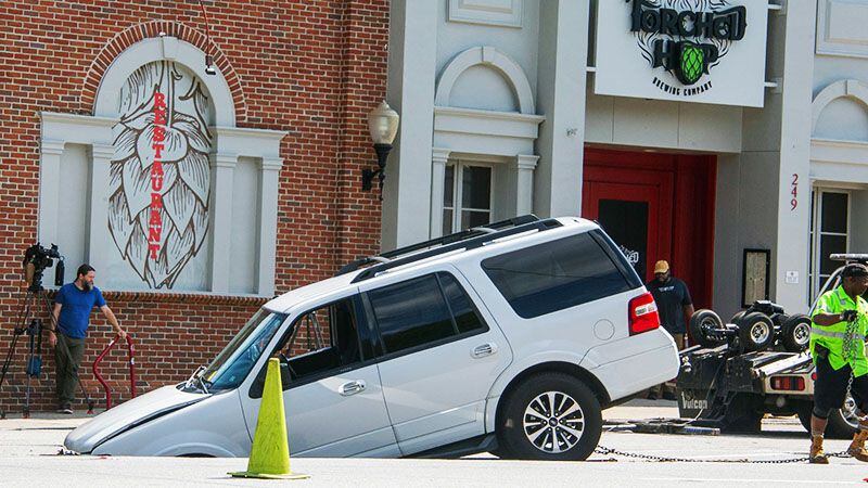 A white SUV fell into a sinkhole in Midtown Atlanta on Tuesday, June 27, 2023.