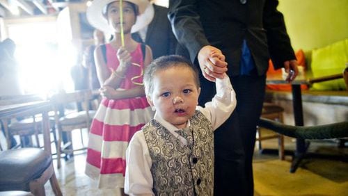 Bounkham Phonesavanh holds his mother Alecia’s hand as they walk to their table during a farewell breakfast at Delightful Eatz in Atlanta on July 2, 2014. JONATHAN PHILLIPS / FOR THE AJC