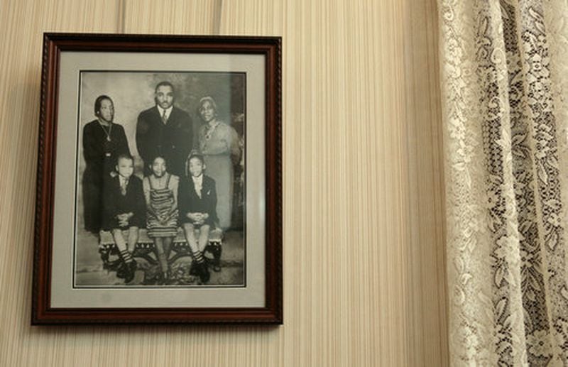 A family photo hangs in the entryway of Martin Luther King Jr.'s childhood home including, clockwise from top left: Alberta Williams King, the Rev. Martin Luther King Sr., Jennie Williams, Alberta's mother, and the three King children, A.D. (Alfred Daniel), Christine and Martin Jr. (Jessica McGowan/AJC file)