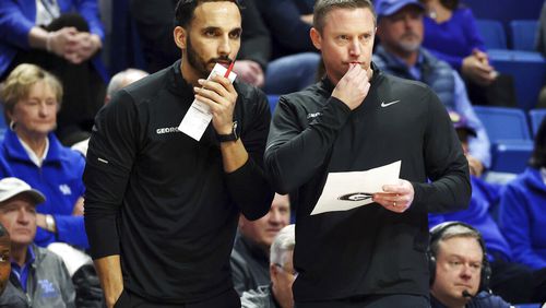 Georgia's assistant coach Erik Pastrana, left, and head coach Mike White study the action during the first half of an NCAA college basketball game against Kentucky in Lexington, Ky., Tuesday, Jan. 17, 2023. (AP Photo/James Crisp)