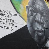 Kevin “Scene” Lewis touches up his mural of civil rights leader John Lewis on Monday, June 24, 2024, off of South Commercial Circle in Warner Robbins, Georgia. Lewis repainted parts of the mural after it was defaced. (Photo Courtesy of Katie Tucker/The Telegraph)
