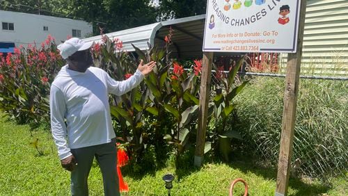 Eric Smith points to a sign at his "literacy garden" on East 10th Street in Chattanooga, TN. The Navy veteran hopes school children will come to read in the garden, which is dedicated to his parents. (Photo Courtesy of Mark Kennedy)
