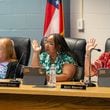 Marietta school board members raise their hand in support of a staff proposal to limit cellphone use by middle school students during its meeting on June 18, 2024. (Ben Hendren for the Atlanta Journal-Constitution)