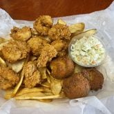 The Po'Boy Shop's coleslaw, shown here with the fried shrimp platter accompanied by hush puppies and Cajun-seasoned fries. 
(Courtesy of the Po'Boy Shop)