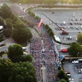 July 4, 2022 Atlanta - Aerial view shows runners cross the starting line of the 53rd Atlanta Journal Constitution Peachtree Road Race near Lenox Square Mall in Atlanta on Monday, July 4, 2022. (Hyosub Shin / Hyosub.Shin@ajc.com)
