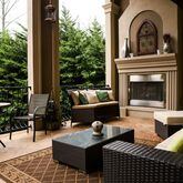 The veranda of Martha and Jean-Francois Morizur’s home looks out over their backyard and pool area. A sofa, chair and coffee table from Wayfair provide seating around the outdoor fireplace, and the fleur-de-lis wood and iron art above the fireplace from Hobby Lobby ties the outdoor decor into the French style of the interior of the home. Text by Shannon Dominy. Photo by Reynolds Rogers.