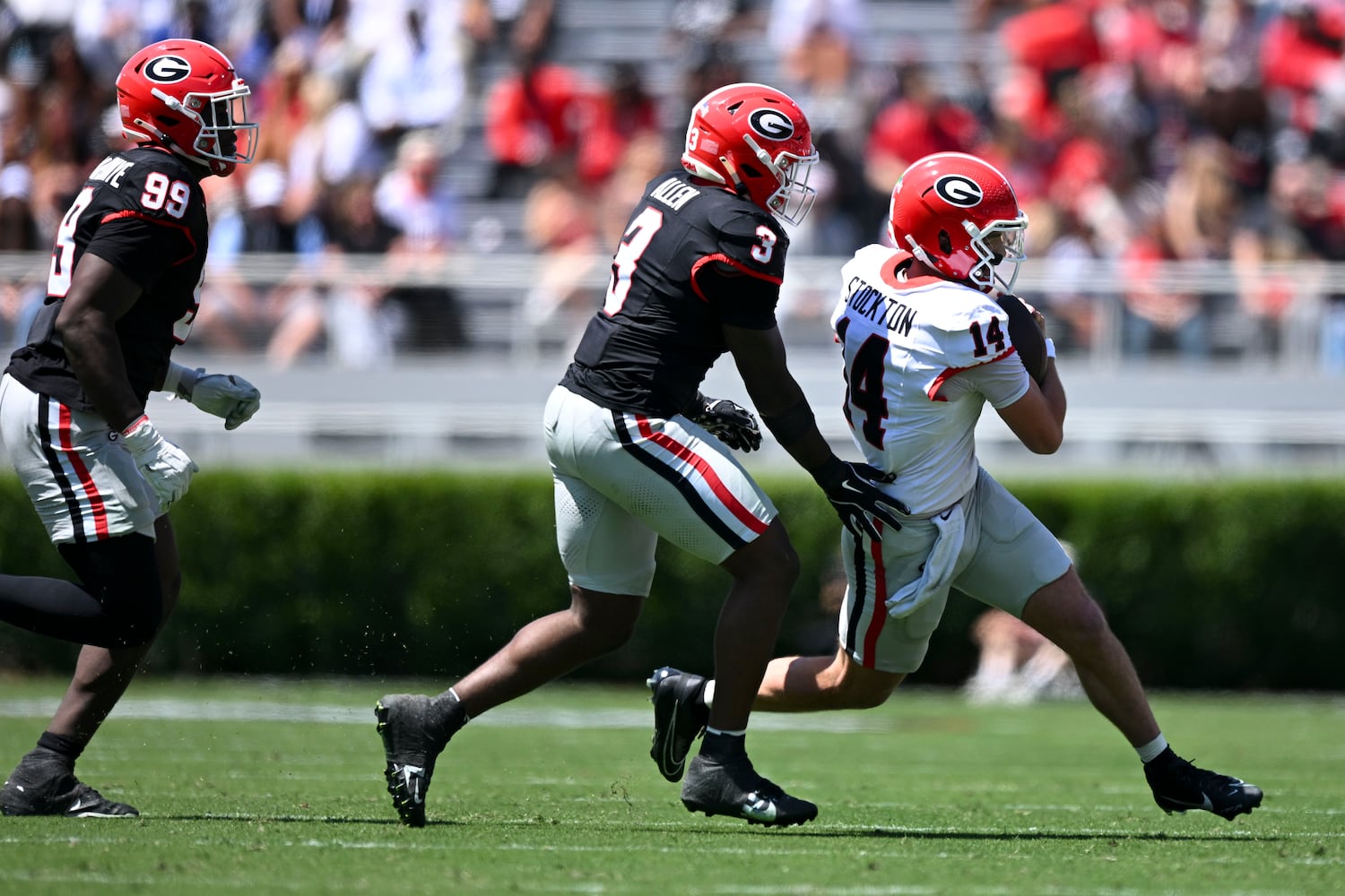 Georgia Red Team’s quarterback Gunner Stockton carries the ball under pressure from Georgia Black Team’s CJ Allen (3) qnd Joseph Jonah-Ajonye (99) during the first half of the G-Day spring football game Saturday, April 12, 2025 at Sanford Stadium in Athens. (Daniel Varnado/For the Atlanta Journal-Constitution)