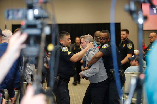 A protester is removed at the town hall for Marjorie Taylor Greene in Acworth on Tuesday,  April 15, 2025. (Jenni Girtman for the AJC)