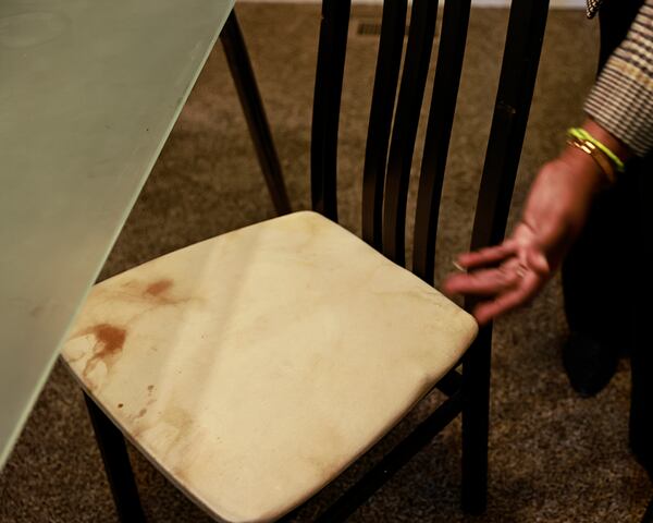 Dele Lowman points to stains on a dining room chair at her Stonecrest rental home in October. After going 98 days without air conditioning, excess humidity caused mold and mildew to grow on the furniture in her home. Though the air conditioning issue finally was addressed, she said the landlord, VineBrook, never fully addressed the mold. (Natrice Miller/natrice.miller@ajc.com)

