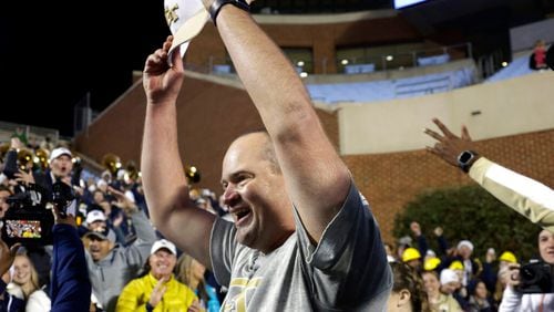 Georgia Tech interim head coach Brent Key celebrates with fans after the team defeated North Carolina in an NCAA college football game, Saturday, Nov. 19, 2022, in Chapel Hill, N.C. (AP Photo/Chris Seward)